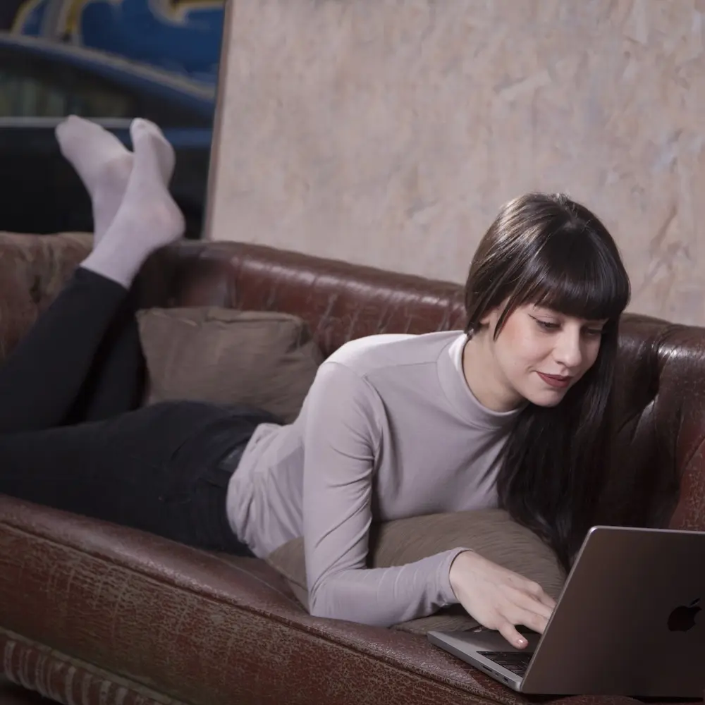 A woman taking a Spanish class via Zoom from her couch